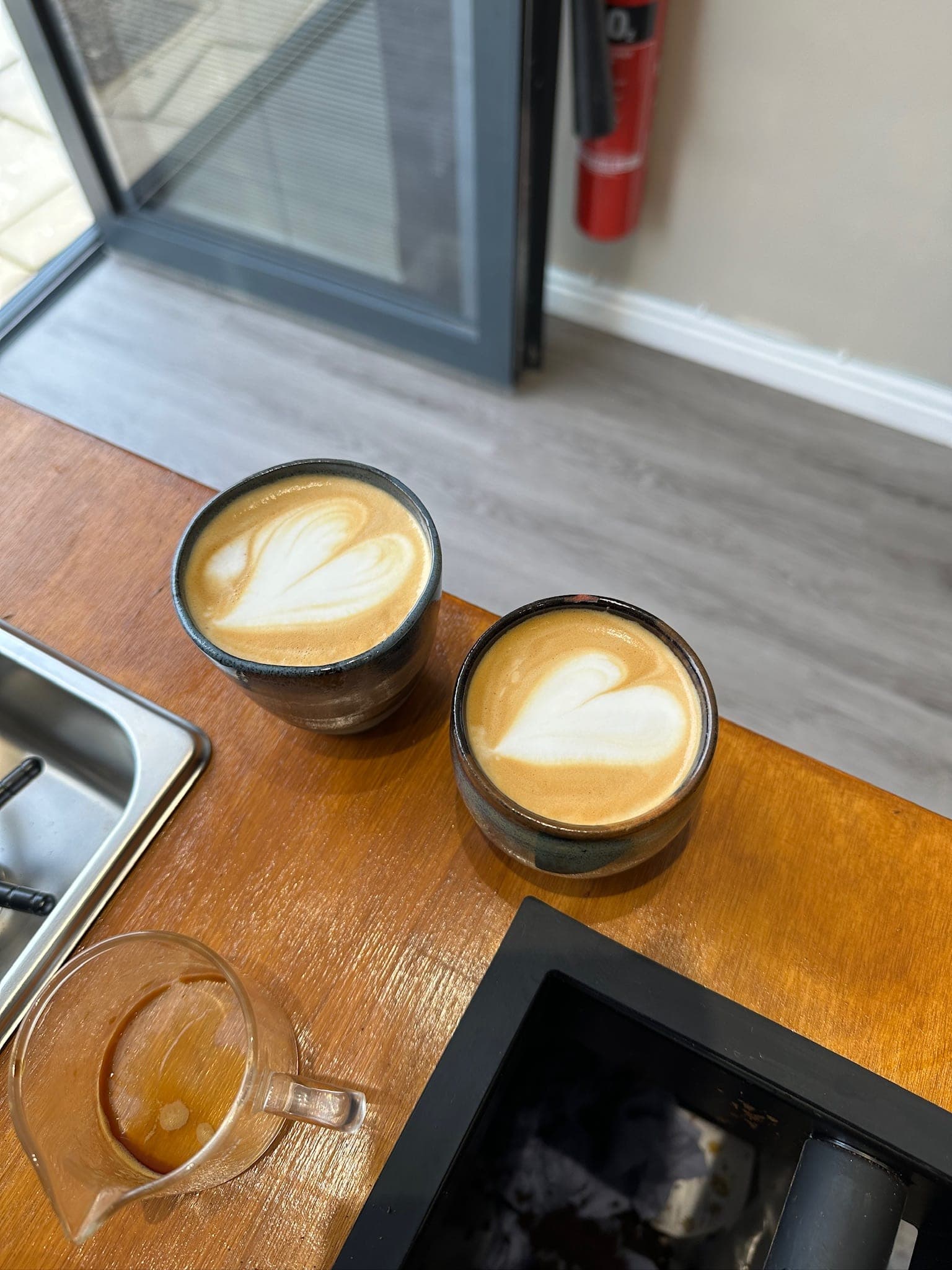 Two latte-art drinks on a table by the window at INYUN on Brentford High Street